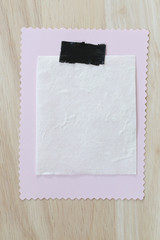 Pink notepad paper of empty and copy space on wooden background.