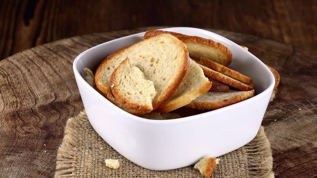 Seamless loopable Bread Chips (4K footage) on a rotating wooden plate