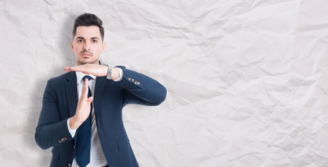 Serious businessman showing time out sign