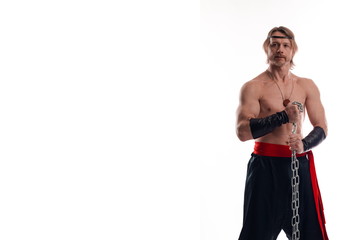 Actor Athlete man in trousers with naked torso training with chain on white background