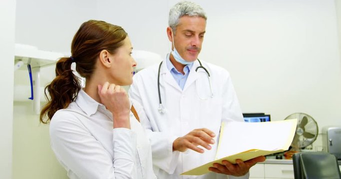 Dentist discussing report with female patient