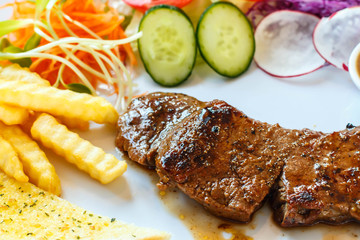 Beef steak with black pepper sauce and vegetables.