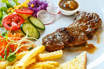 Beef steak with black pepper sauce and vegetables.