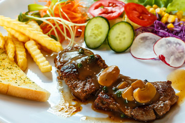 Beef steak with black pepper sauce and vegetables.