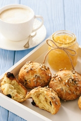 Home breakfast - homemade cheese bread rolls with cranberries, almond ans sunflower seeds and cup of coffee.