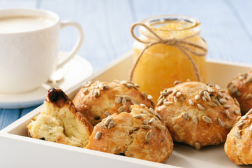 Home breakfast - homemade cheese bread rolls with cranberries, almond ans sunflower seeds and cup of coffee.