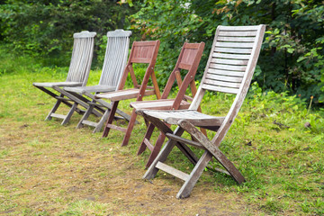 Setr of old wooden chairs of different design in a garden