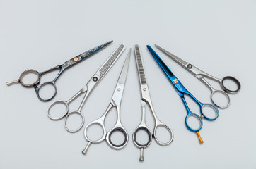 hairdressing equipment like different scissors on gray wooden table in professional  salon with...