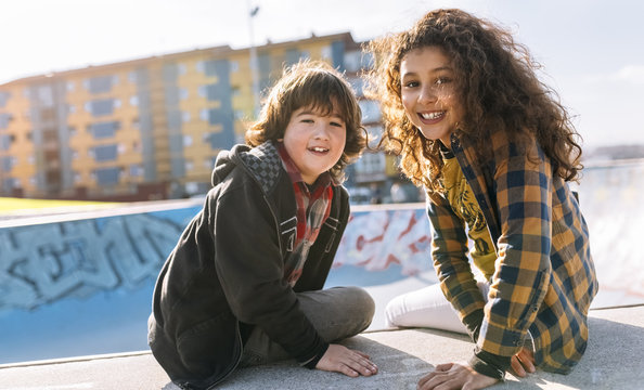 Portrait Of Two Children Sitting On A Wall