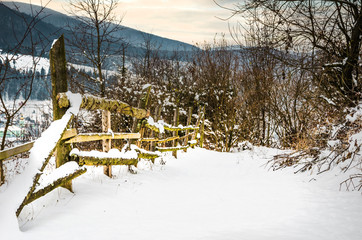 Winter landscape wooden fence in winter mountains are nestled in