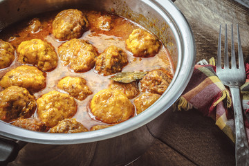 Homemade Meat balls in tomato and curry sauce on wooden backgrou