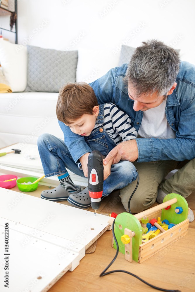 Wall mural Father and son assembling furniture