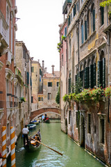 Obraz na płótnie Canvas Gondolier on a gondola ride tourists. The scene on the water streets of Venice, Italy.