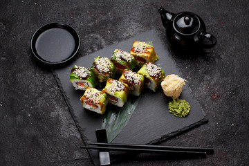 Japanese cuisine. Sushi set on a stone plate and concrete background.