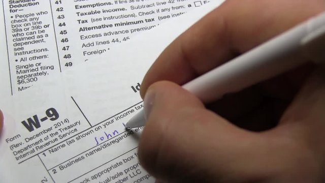 Businessman Signs IRS W-9 Tax Form
