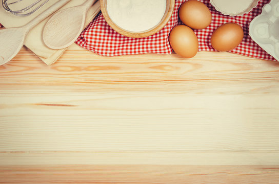 Baking a cake or pizza ingredients background. Top view photograph with kitchen utensils on vintage, natural, raw, wooden background with visible texture.