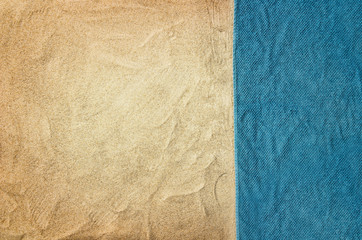 Top view of sandy beach with towel frame. Background with copy space and visible sand texture.
