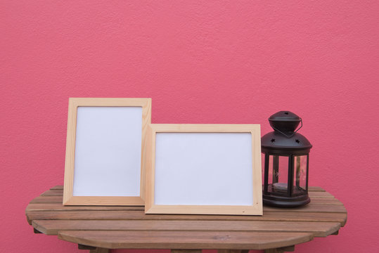 photo Frame on a wooden and Lantern on pink background .