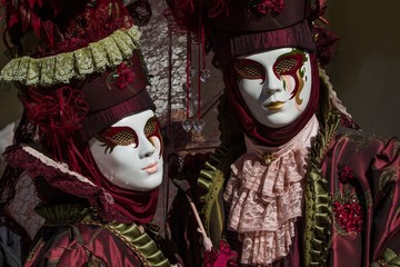 Picturesque photography of beautiful couple with colored costume and venetian mask during Venice Carnival  symbol of tradition, refinement and artistic creativity