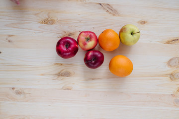 Fresh red and green apple, orange on wooden decks.