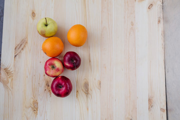 Fresh red and green apple, orange on wooden decks.