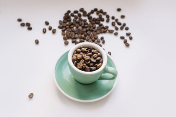fresh morning coffee beans in a small espresso cup on a white background