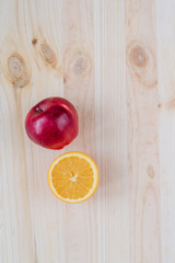 Fresh red and green apple, orange on wooden decks.