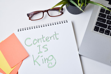  modern White office desk table with text  writing content is king on note book.Top view with copy space, flat lay.