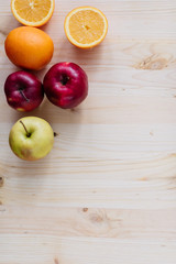 Fresh red and green apple, orange on wooden decks.