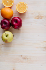 Fresh red and green apple, orange on wooden decks.