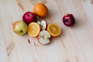 Fresh red and green apple, orange on wooden decks.