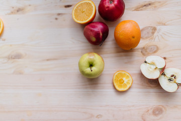 Fresh red and green apple, orange on wooden decks.