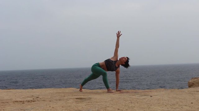 Girl practising yoga at the beach