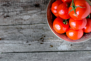 Fresh tomatoes, local market vegetables in a bowl on rustic table
