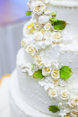 White wedding cake with flowers and blueberries.