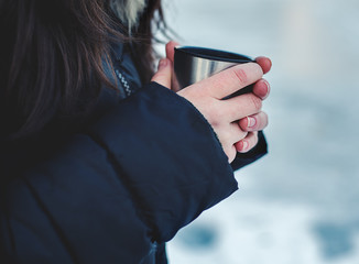 cup of hot tea in female hands. The winter time