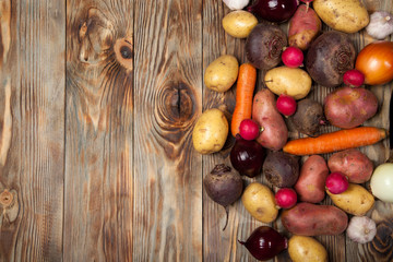 Vegetables. Potatoes, carrots, onions, beets and radishes on a rustic background