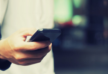 Blurred focus of a man using mobile smart phone, vintage color filter
