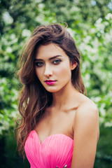 Naklejka premium Portrait of young beautiful woman posing among blooming apple trees.