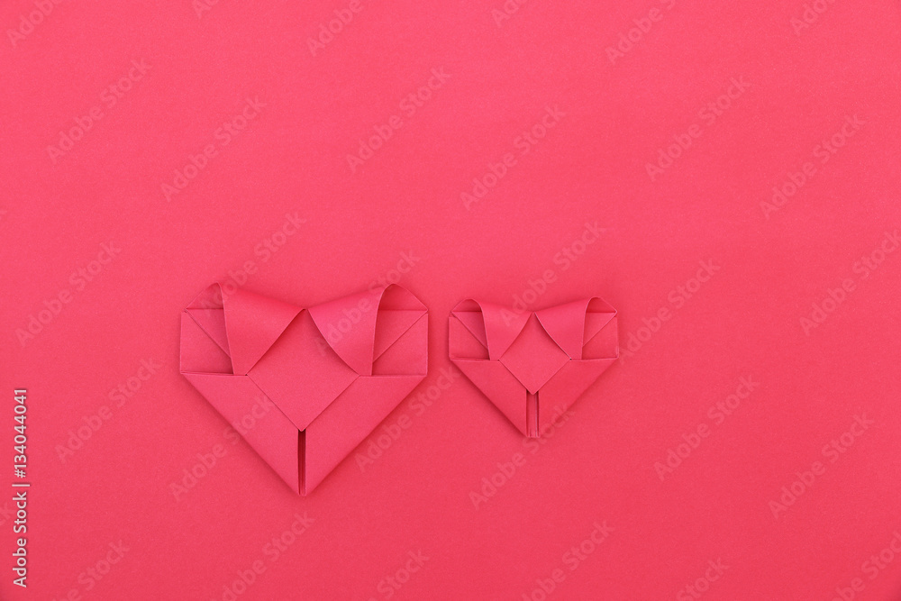 Poster two folding red paper hearts on red for pattern and background