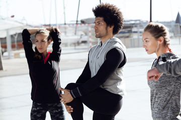 Fit and sporty team stretching in the city.