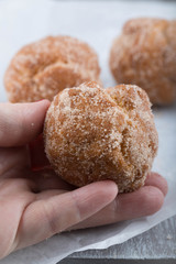 Donut hole rolled in a female hand 
