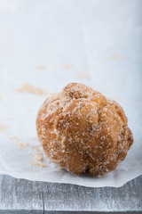 Donut hole rolled in cinnamon sugar on awhite paper. 