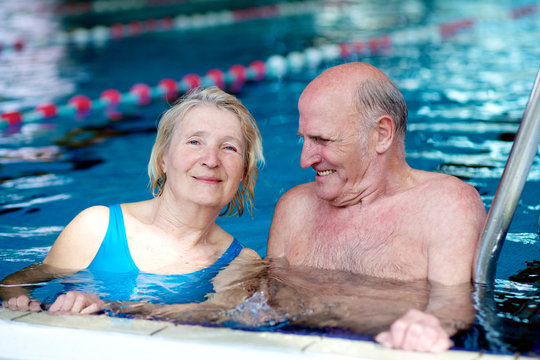 Happy healthy active senior couple having fun together in the swimming pool - Powered by Adobe