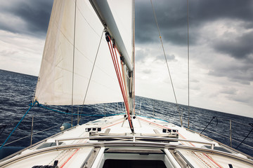 Sailboat sailing through the Mediterranean under a storm.