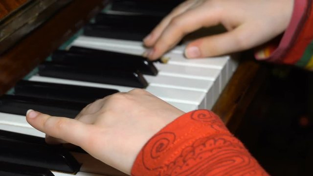 kid hands on a piano key
