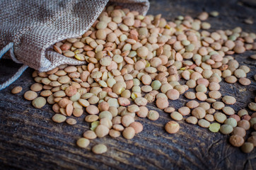 Brown dried lentils in a burlap bag
