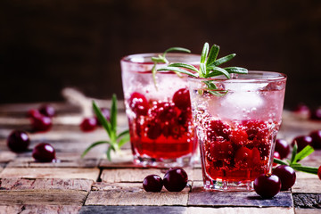 Two-layer cocktail with cranberry vodka, rosemary, soda and ice,