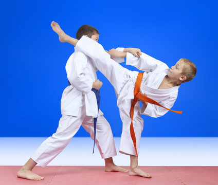 Children in karategi are training blows arm and leg