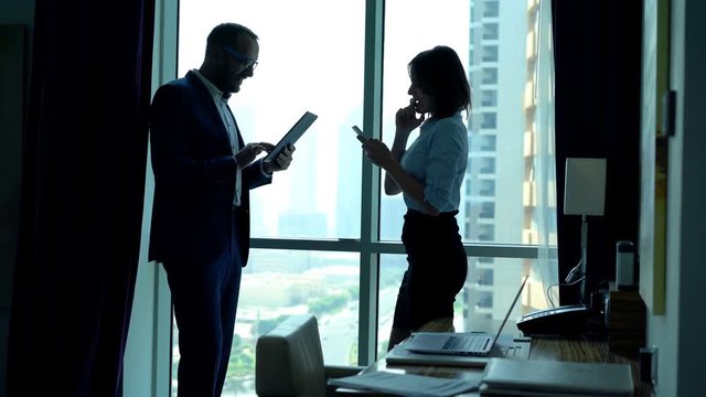 Happy businesspeople getting good news on smartphone and tablet in office
